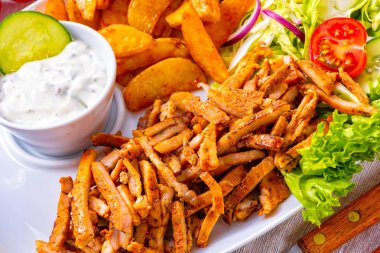 gyros plaka yeşil salata, zeytin ve patates dilimleri