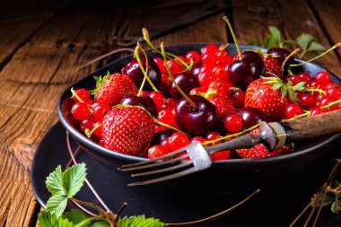 Çilek, frenk üzümü ve kiraz gibi farklı meyve ile kase.