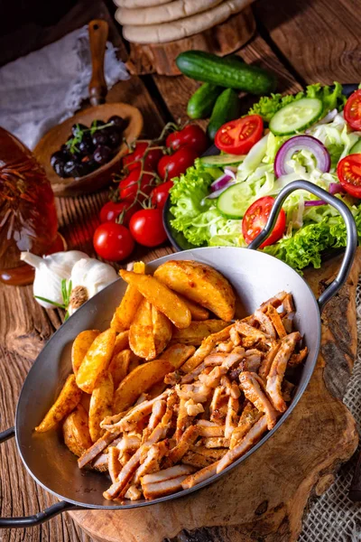 rustik gyros yakından görmek yeşil salata ve patates dilimleri plaka