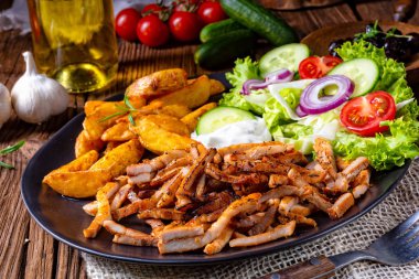 Gyros plaka yeşil salata ve patates dilimleri ile