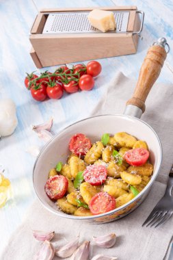 Gnocchi pişmiş yeşil pesto, kiraz domates ve parmesan ile