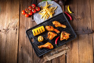 Rustik ızgara tavuk kanatlar, bacaklar ve baharatlı mısır