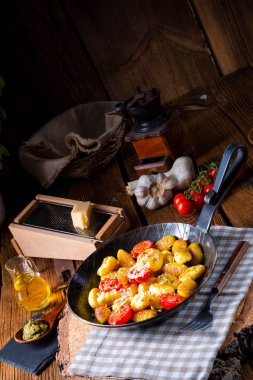 Gnocchi pişmiş yeşil pesto, kiraz domates ve parmesan ile