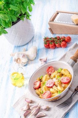 Gnocchi pişmiş yeşil pesto, kiraz domates ve parmesan ile