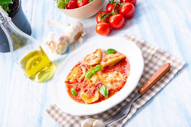 Fesleğenli domates soslu lezzetli Mantı yaprakları beyaz tabağında, yakın çekim 