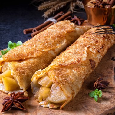 Lezzetli sonbahar omas krep ile elma ve tarçın tahta kesme tahtası üzerinde