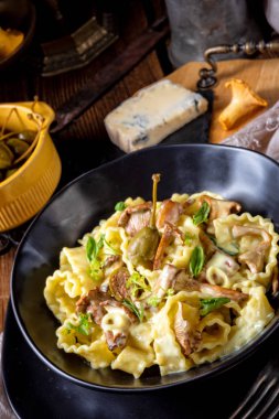 Krema soslu taze chanterelles ve siyah plaka Kapari Reginette erişte