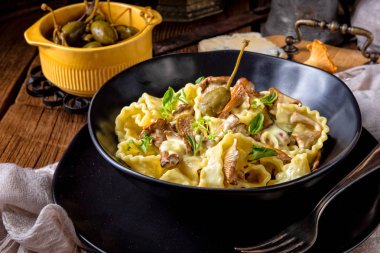 Krema soslu taze chanterelles ve siyah plaka Kapari Reginette erişte