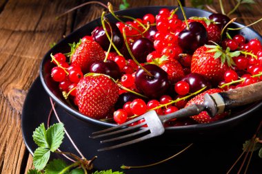 Çilek ve kırmızı kuş üzümü ve kirazı ile kase 