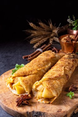 Lezzetli sonbahar omas krep ile elma ve tarçın tahta kesme tahtası üzerinde