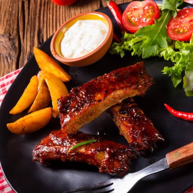 Barbekü kaburga plaka yeşil salata ve beyaz sos ile