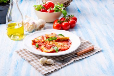 Fesleğenli domates soslu lezzetli Mantı yaprakları beyaz tabağında, yakın çekim 