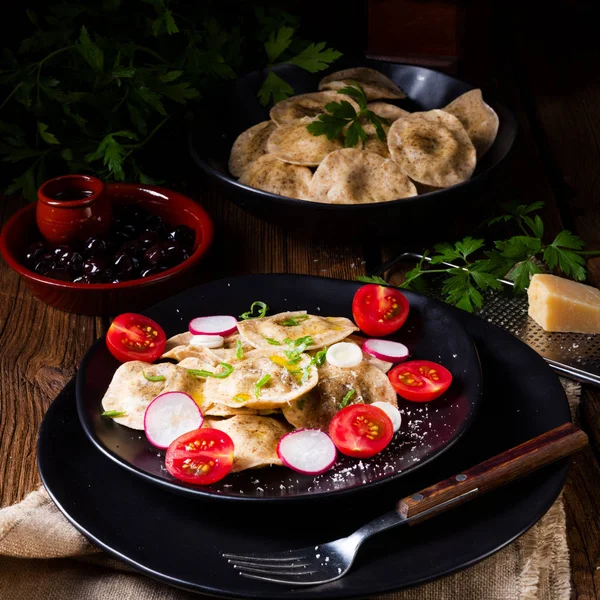 Bezelye ve domates ve turp plaka üzerinde zeytin yağı ile organik Mantı 