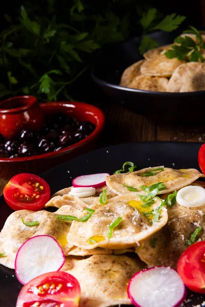 Bezelye ve domates ve turp plaka üzerinde zeytin yağı ile organik Mantı 