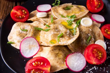 Bezelye ve domates ve turp plaka üzerinde zeytin yağı ile organik Mantı 