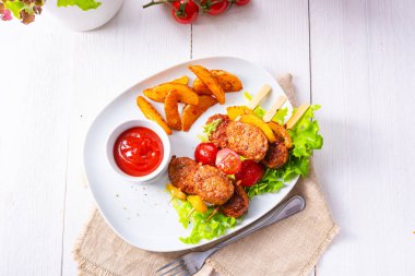 Pişmiş domates ve fırında patates dilimleri ile köfte