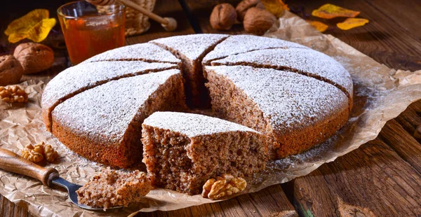 Walnut cake with honey and powdered sugar on baking paper