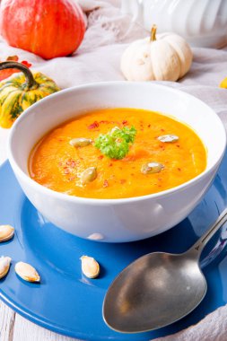 Zencefilli havuç ve beyaz kase içinde Hindistan cevizi sütü ile sağlıklı kabak çorbası