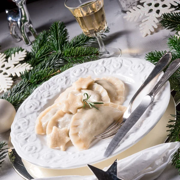 波兰风格的饺子 里面装满了泡菜和白色盘子上的蘑菇 背景是圣诞装饰 — 图库照片