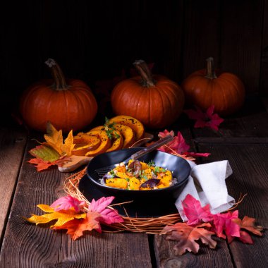 arka plan üzerinde plaka ile Gratine Vejetaryen Kabak ile arpa kabuğu çıkarılmış tane ve Erik kekik ve sonbahar yaprakları 