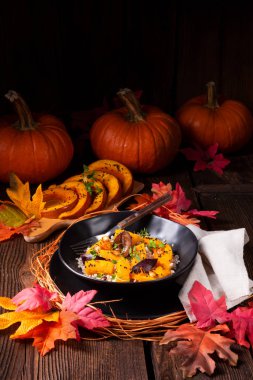 arka plan üzerinde Gratine Vejetaryen Kabak arpa kabuğu çıkarılmış tane ve erik ve kekik plaka ile sonbahar yaprakları 
