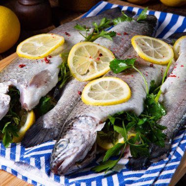 Limonlu taze alabalık ve farklı otlar.