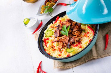 Beyaz arka planda kuskus, sebze ve etli Tajin.