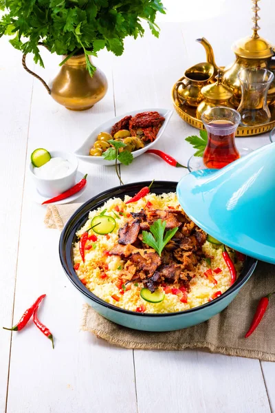 Tajín con cuscús, verduras y carne sobre fondo blanco —  Fotos de Stock