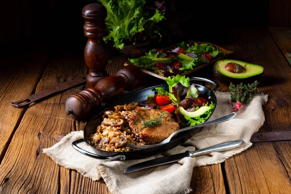 Стейк зі свинини з грибами та гречкою та салат з манго — стокове фото