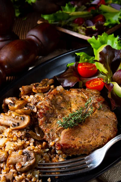 Steak de porc aux champignons et gruaux de sarrasin et salade de mangue — Photo