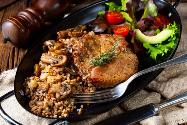 Steak de porc aux champignons et gruaux de sarrasin et salade de mangue — Photo