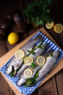 Limonlu taze alabalık ve farklı otlar.