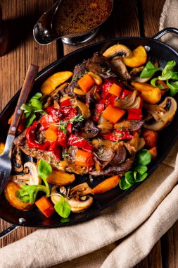 Çeşitli sebzelerle kaplı yumuşak sığır eti.