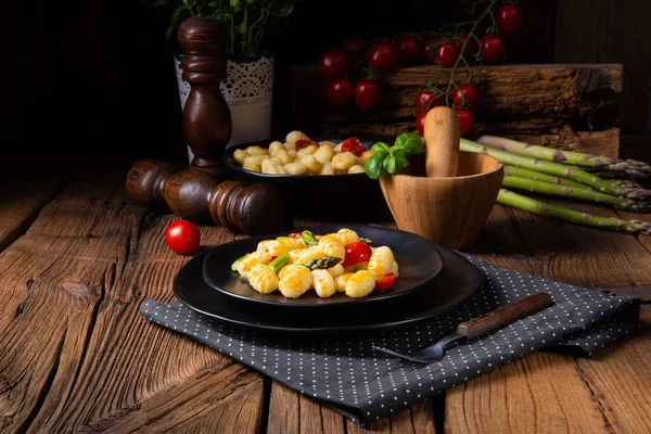 Knusprige Gnocchi mit gebratenem Spargel und Tomaten — Stockfoto