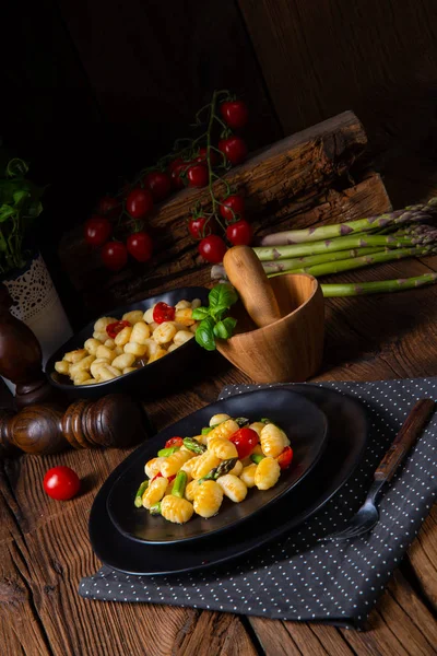 Knusprige Gnocchi mit gebratenem Spargel und Tomaten — Stockfoto