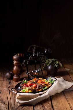 Çeşitli sebzelerle kaplı yumuşak sığır eti.