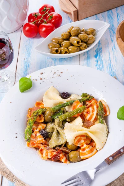 Kleurrijke farfalle met groene asperges olijven en parmaham — Stockfoto