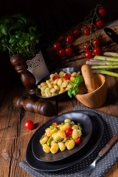 Gnocchi croccanti con asparagi arrosto e pomodori — Foto Stock