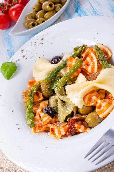 Farfalle colorido con aceitunas de espárragos verdes y jamón de parma —  Fotos de Stock