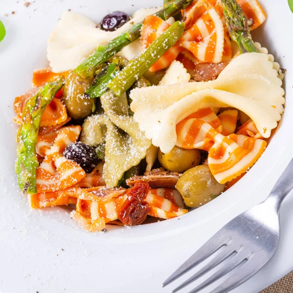 Farfalle colorido com azeitonas espargos verdes e presunto de parma — Fotografia de Stock