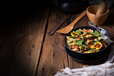 Yeşil kuşkonmaz, zeytin ve jambonlu makarna salatası.