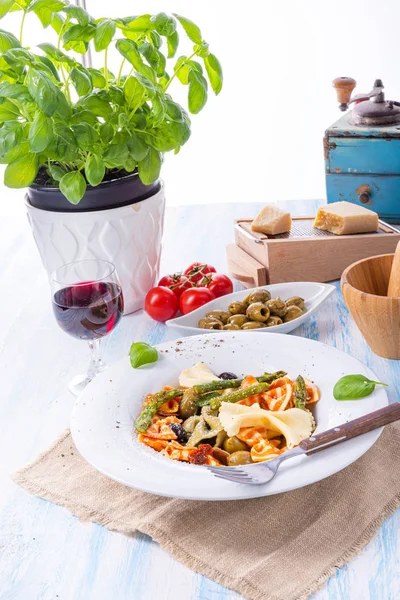 Kleurrijke farfalle met groene asperges olijven en parmaham — Stockfoto