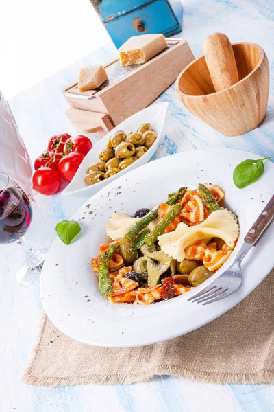 Yeşil kuşkonmaz zeytinli ve parma jambonlu renkli farfalle.