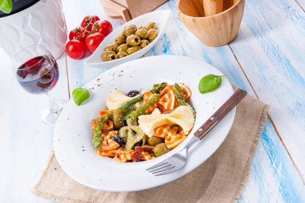 Färgglada farfalle med grön sparris oliver och parmaskinka — Stockfoto