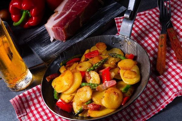 Gebratene Kartoffeln mit geräuchertem Speck, grünem Spargel und Paprika. — Stockfoto