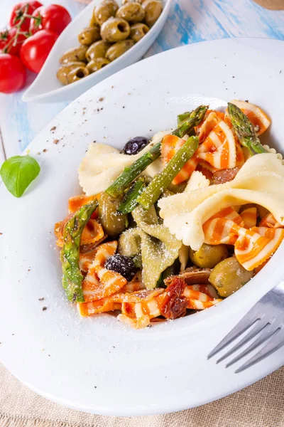 Farfalle colorido con aceitunas de espárragos verdes y jamón de parma —  Fotos de Stock