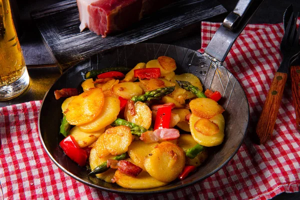 Gebratene Kartoffeln mit geräuchertem Speck, grünem Spargel und Paprika. — Stockfoto