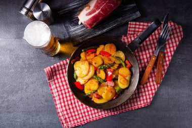 Kızarmış patates, füme pastırma, yeşil kuşkonmaz ve kırmızı biber..