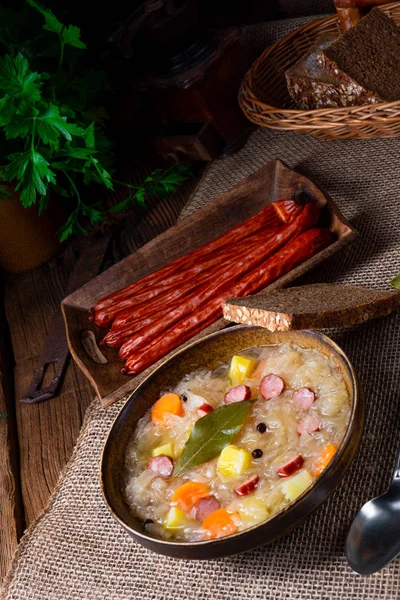 Сільський суп з квашеної капусти з беконом та ковбасою — стокове фото