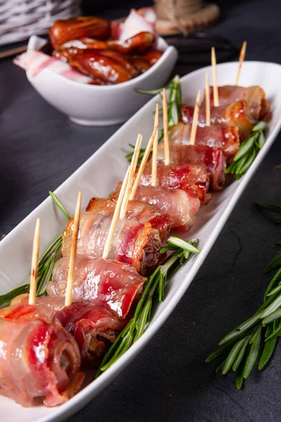 Dates wrapped in bacon and delicious tapas — Stock Photo, Image